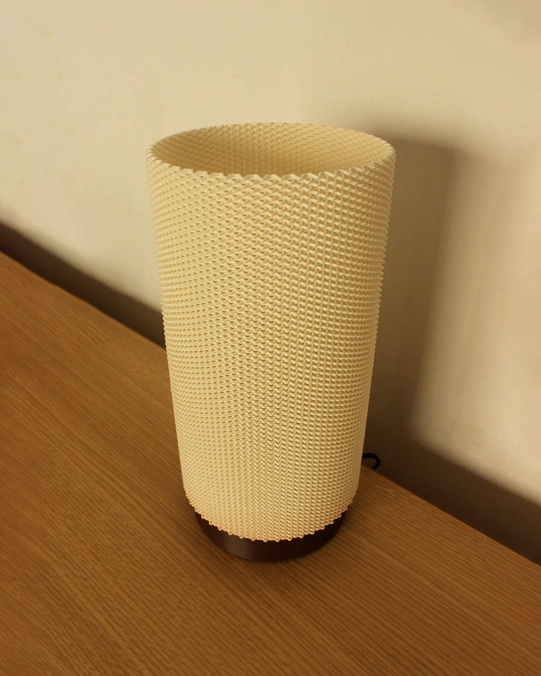 a white vase sitting on top of a wooden table