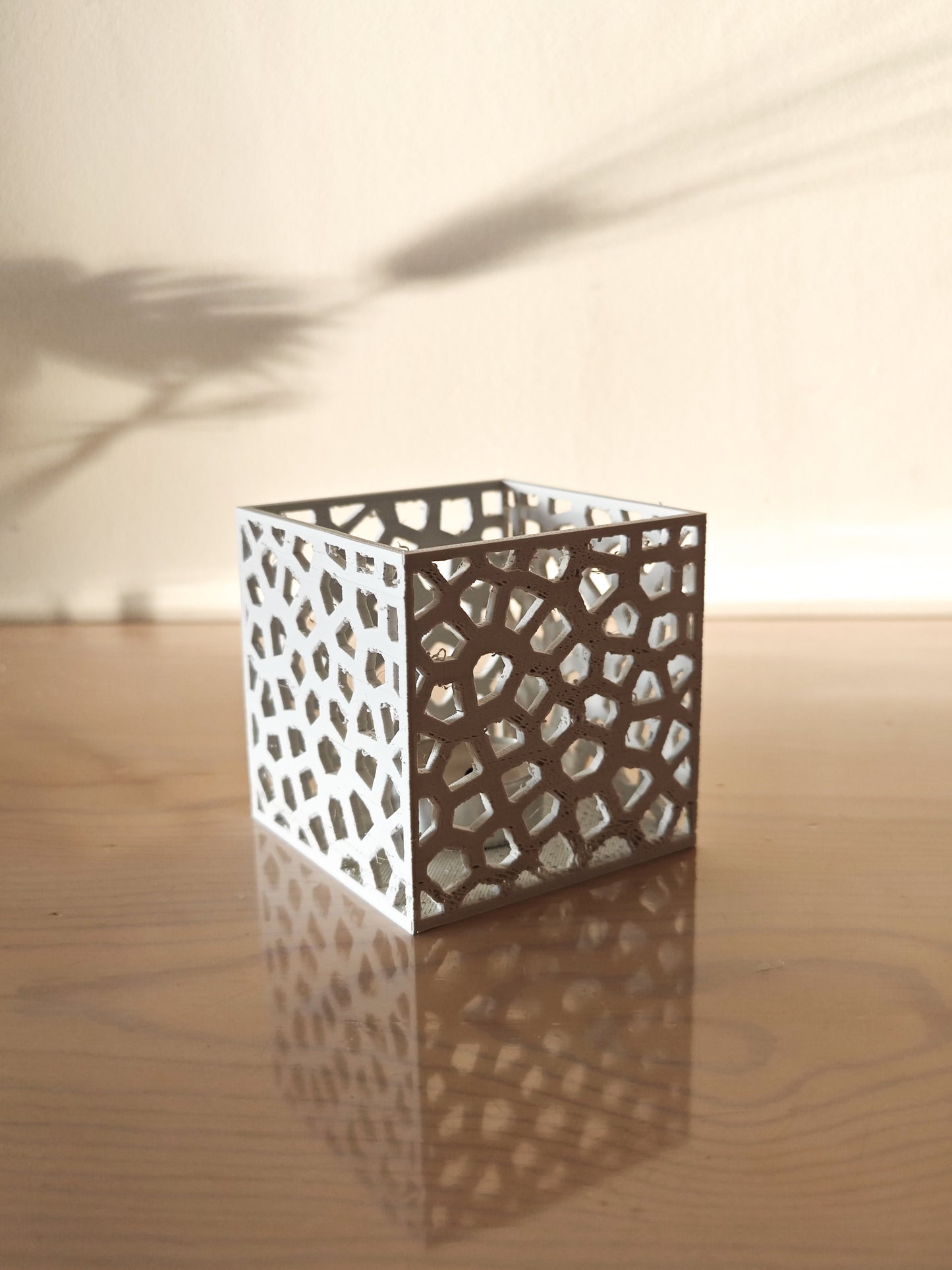 a white vase sitting on top of a wooden table