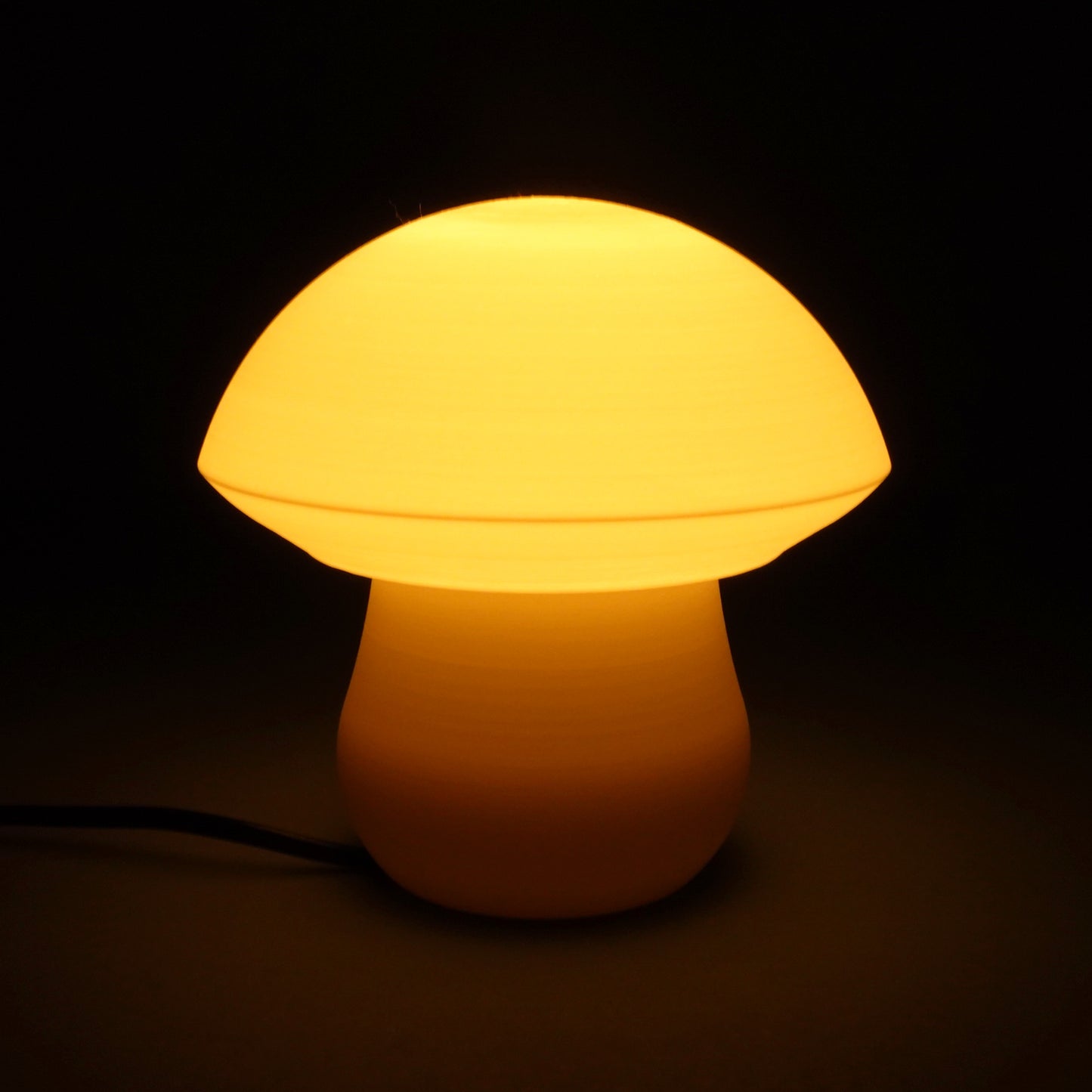 a yellow mushroom shaped light on a black background