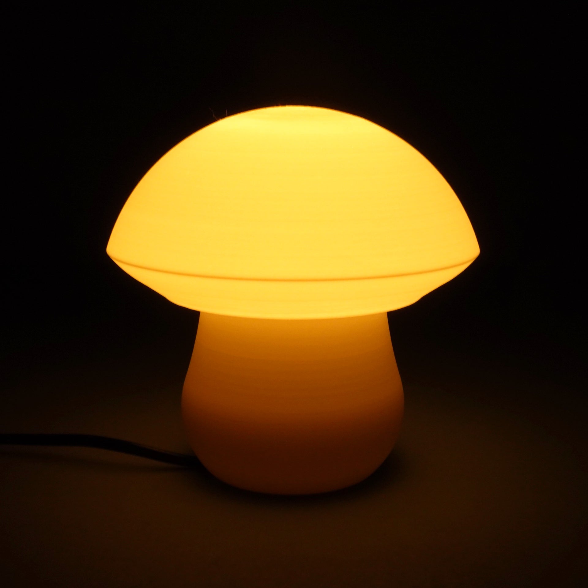 a yellow mushroom shaped light on a black background