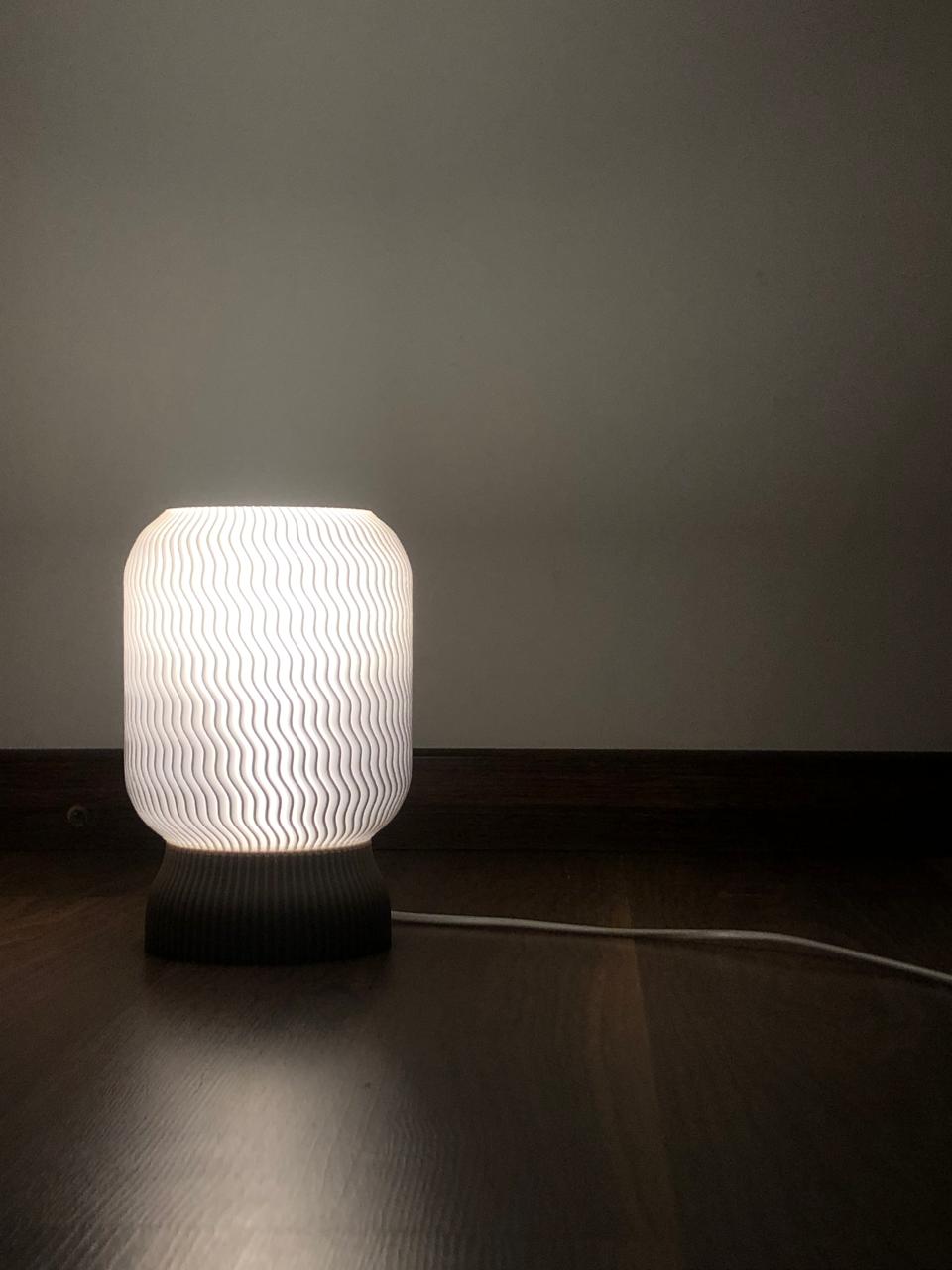 a white lamp sitting on top of a wooden table