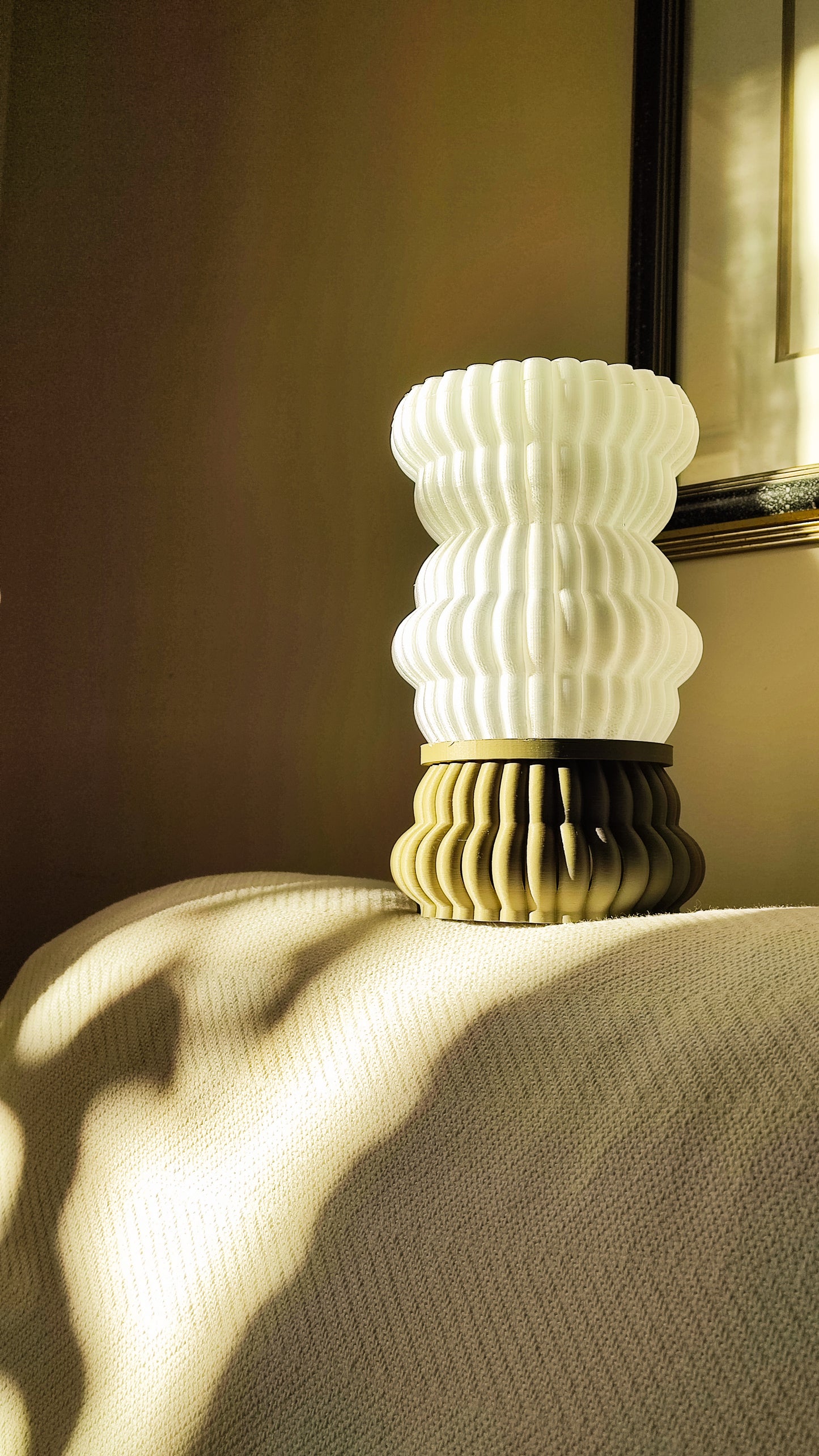 a white vase sitting on top of a bed