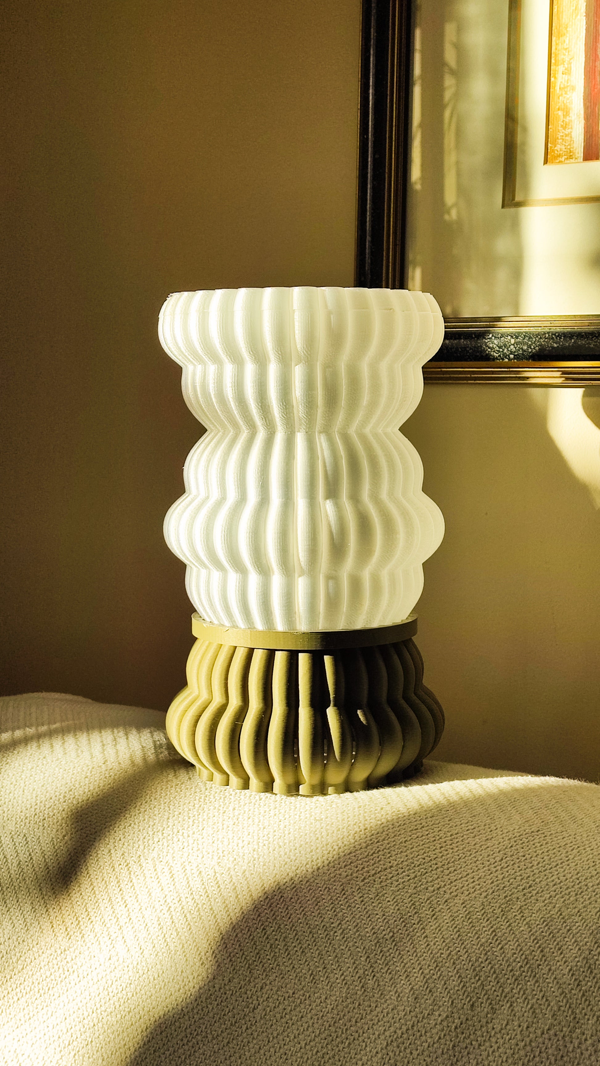 a white vase sitting on top of a bed