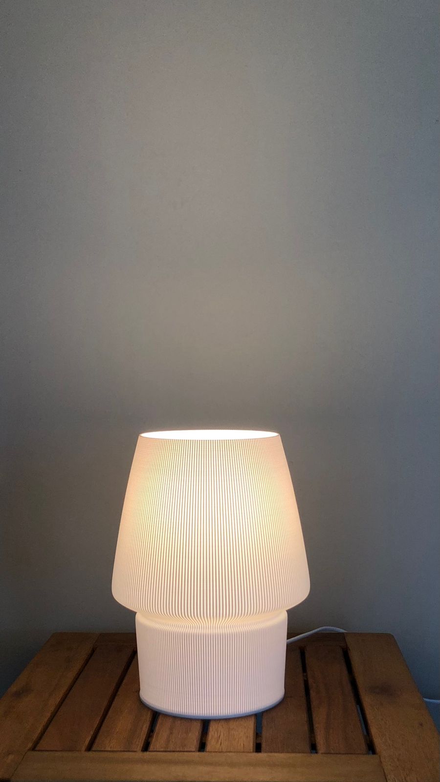 a white lamp sitting on top of a wooden table