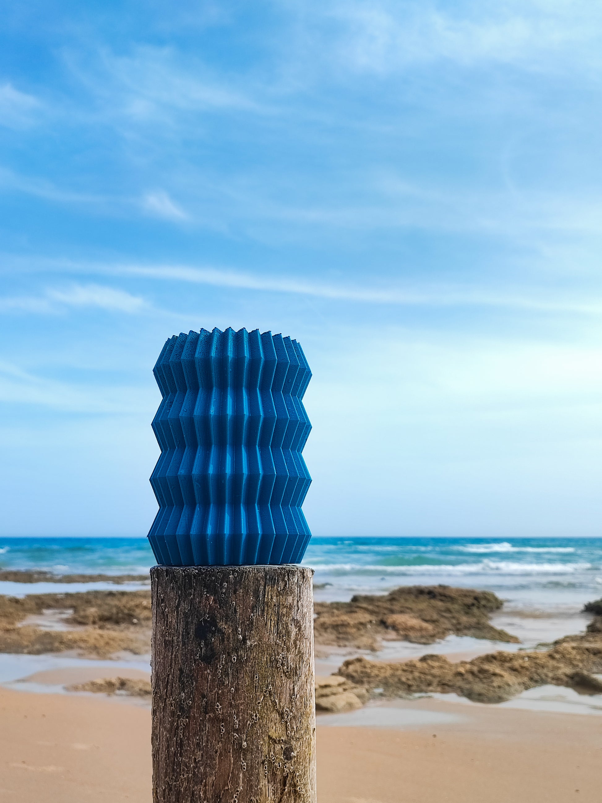 a wooden post with a blue sculpture on top of it