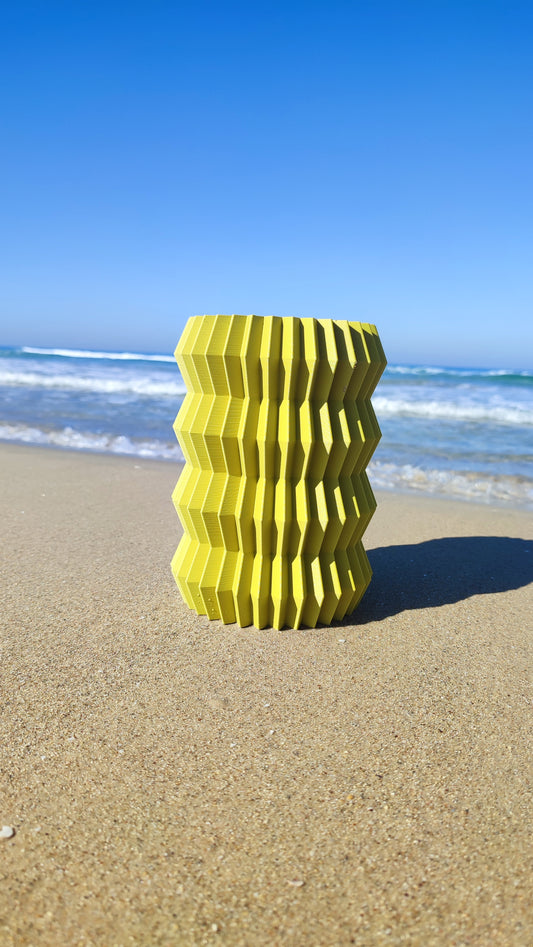 a yellow object sitting on top of a sandy beach