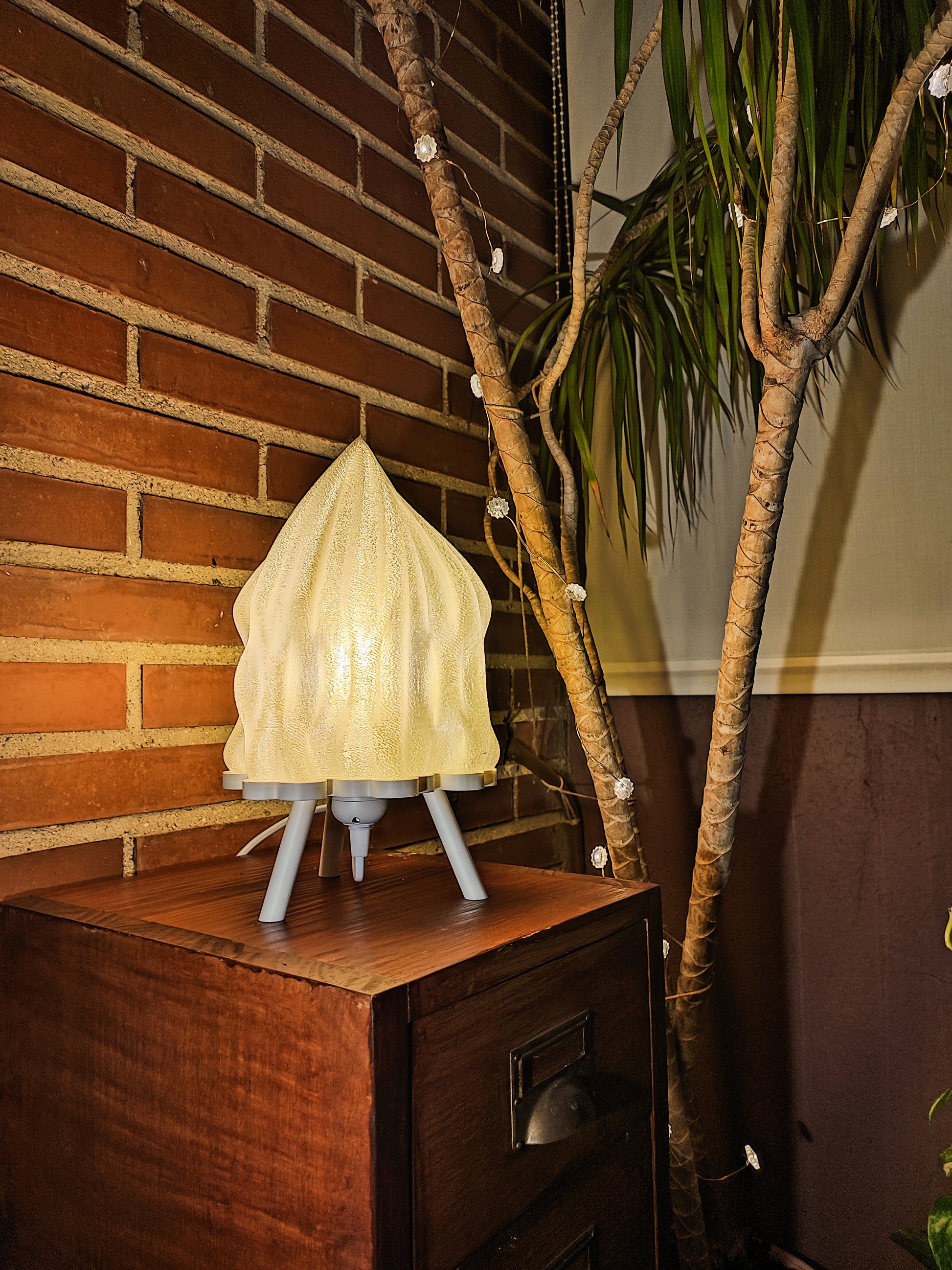 a table with a lamp on top of it next to a tree