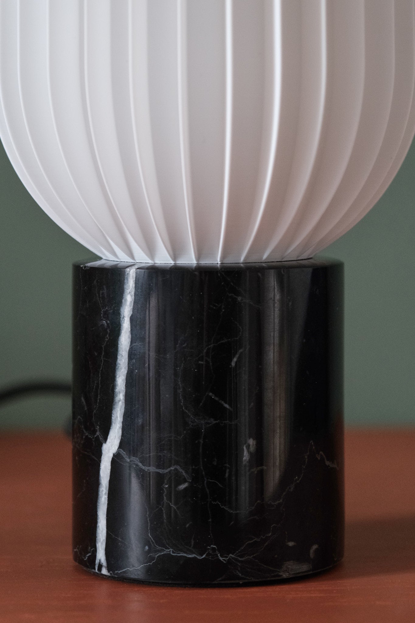 a black and white lamp sitting on top of a wooden table