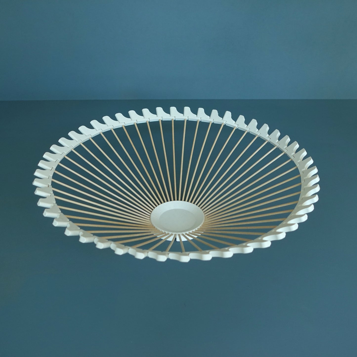 a white ceiling fan on a blue wall