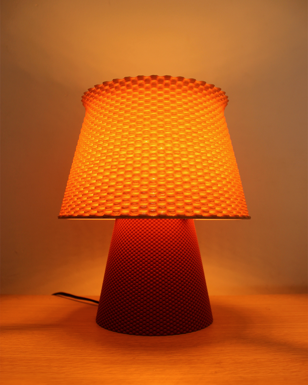 a red lamp sitting on top of a wooden table