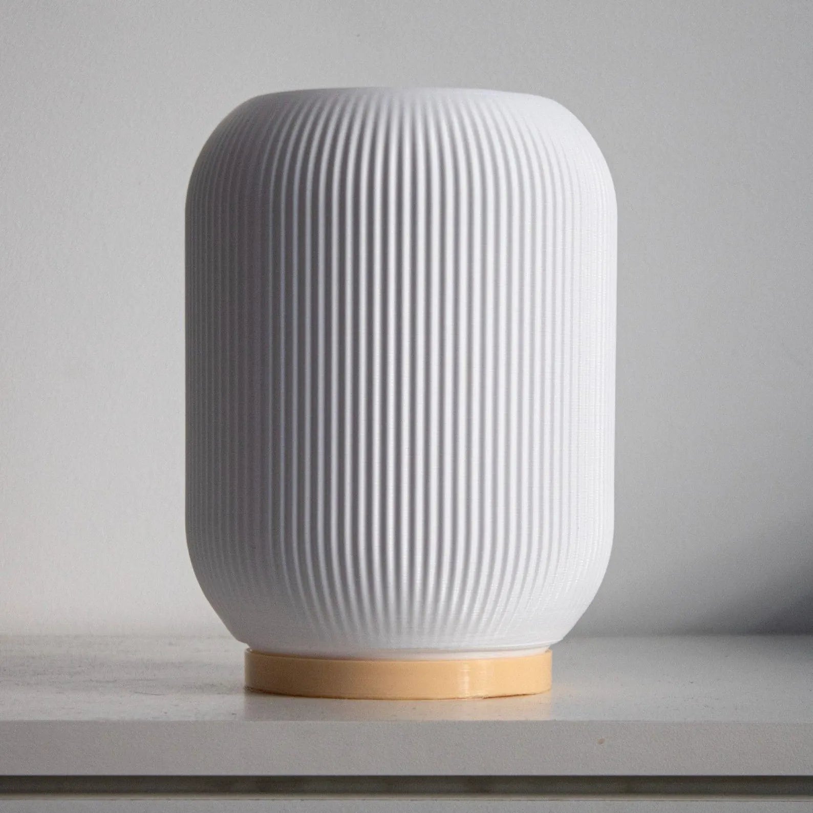 a white vase sitting on top of a table