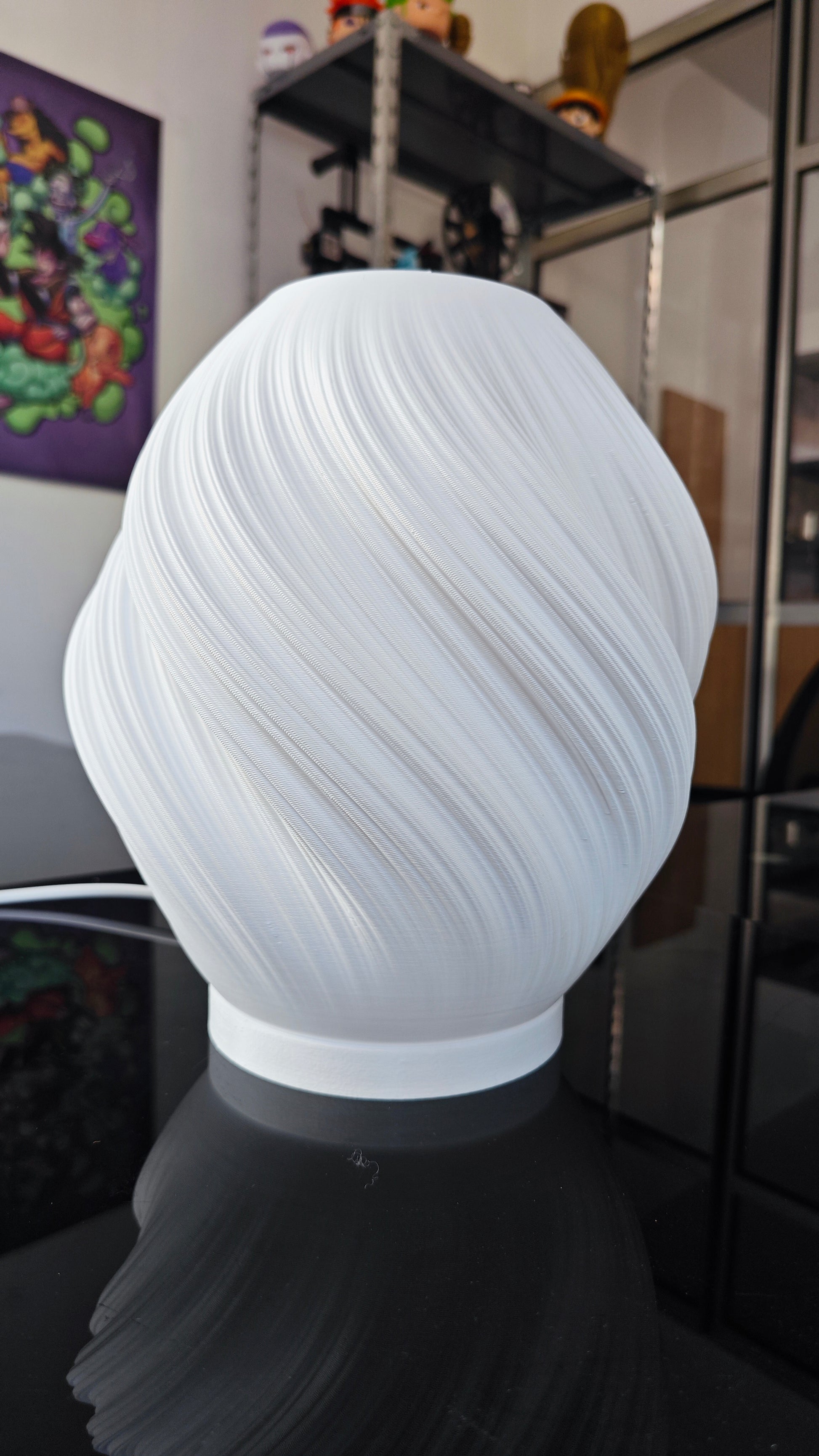 a white vase sitting on top of a black table
