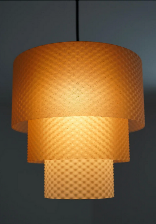 A modern, three-light pendant lamp with a textured orange shade, hanging from a black cord.