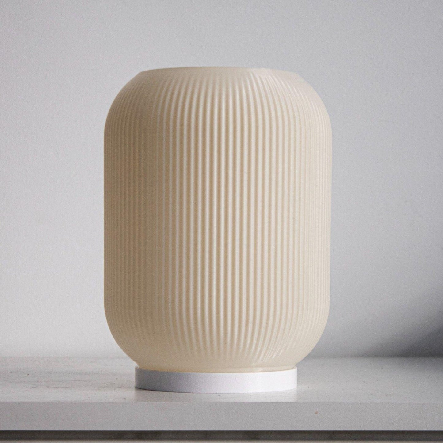 a white vase sitting on top of a table