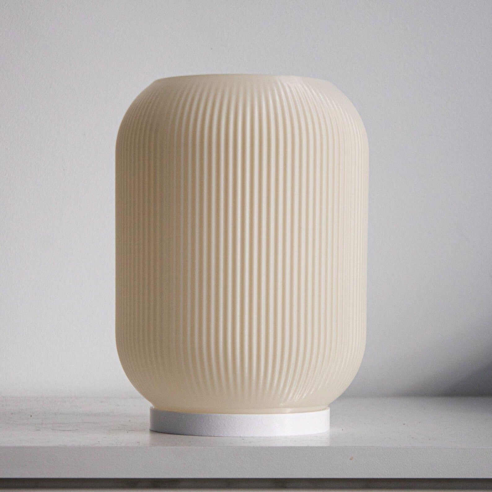 a white vase sitting on top of a table