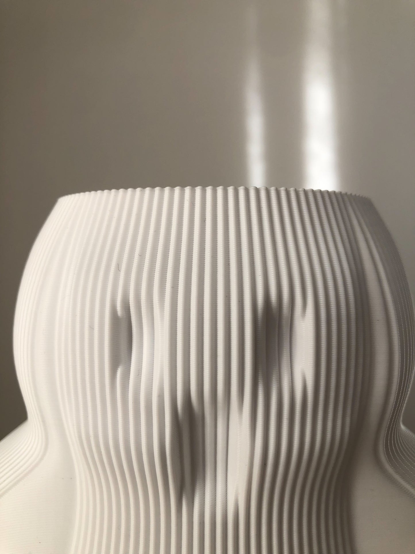 a white vase sitting on top of a table