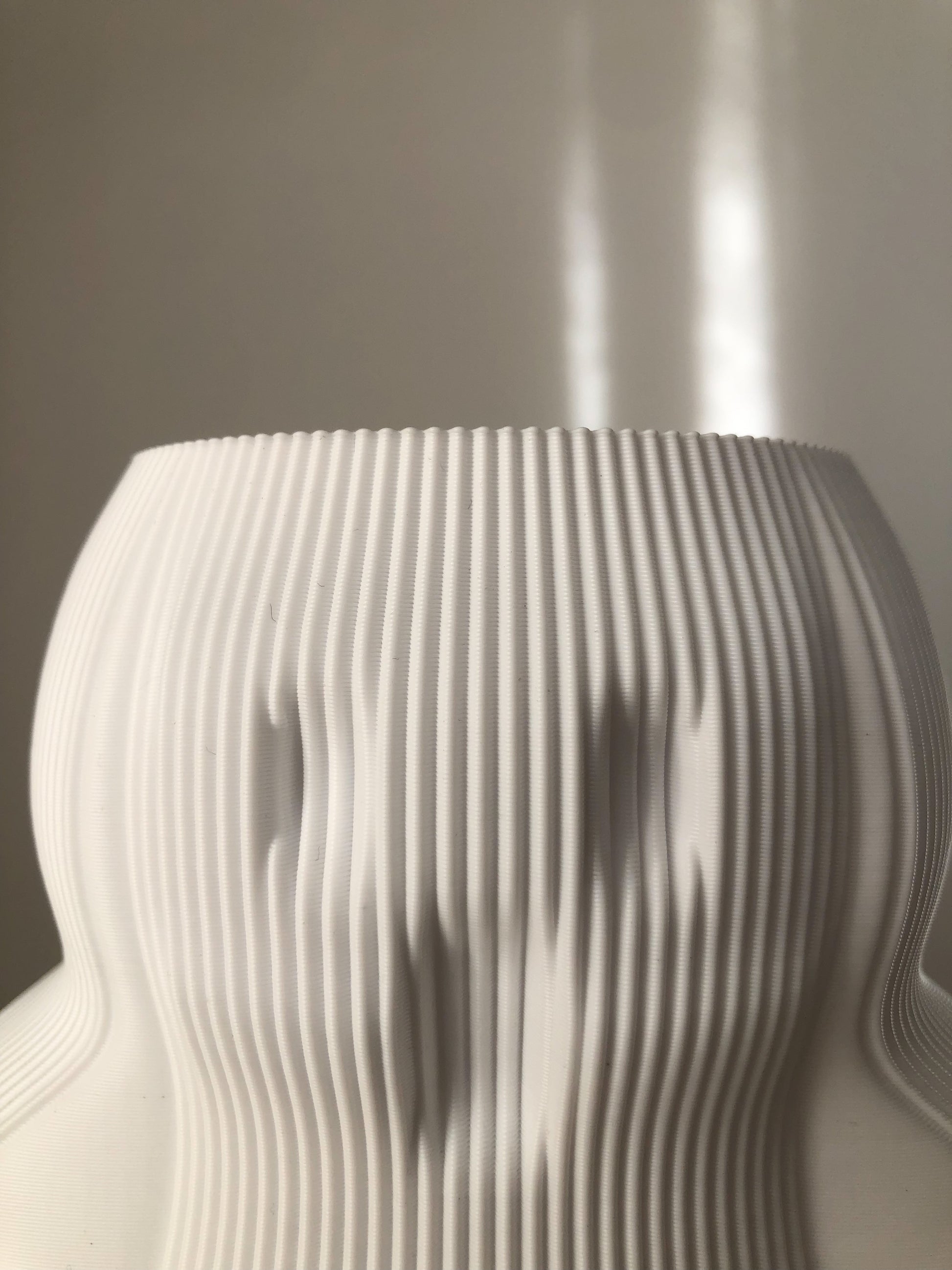 a white vase sitting on top of a table