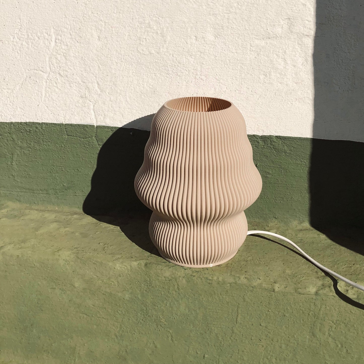 a vase sitting on the ground next to a wall