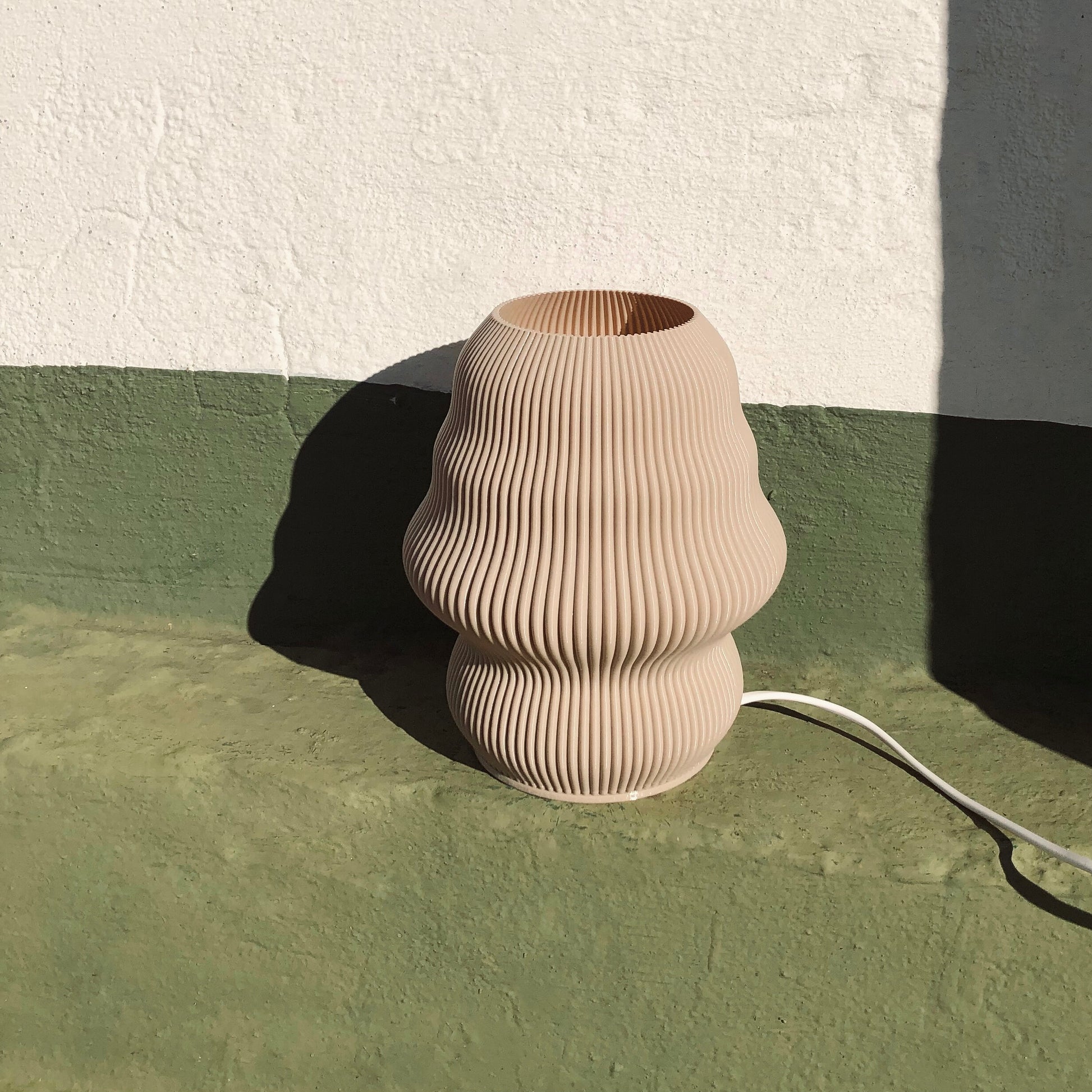 a vase sitting on the ground next to a wall