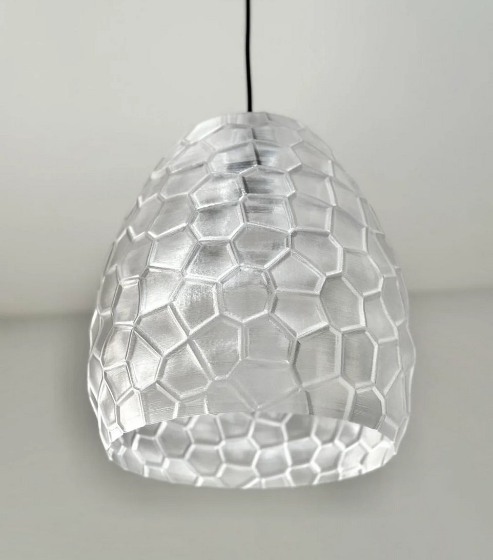A modern, geometric pendant light with a clear, hexagonal pattern that creates a visually striking and minimalist design.