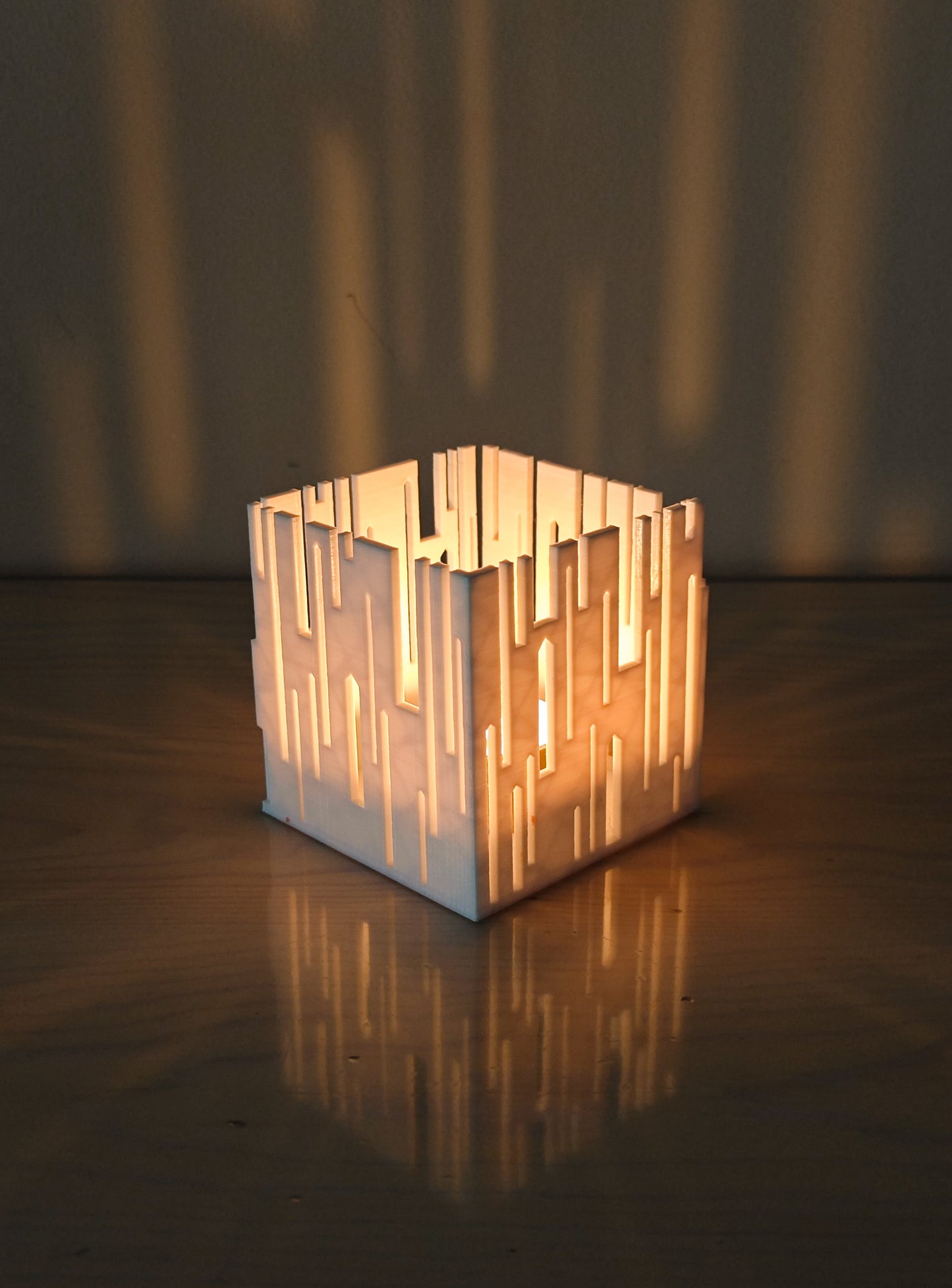 a lit candle holder sitting on top of a wooden table