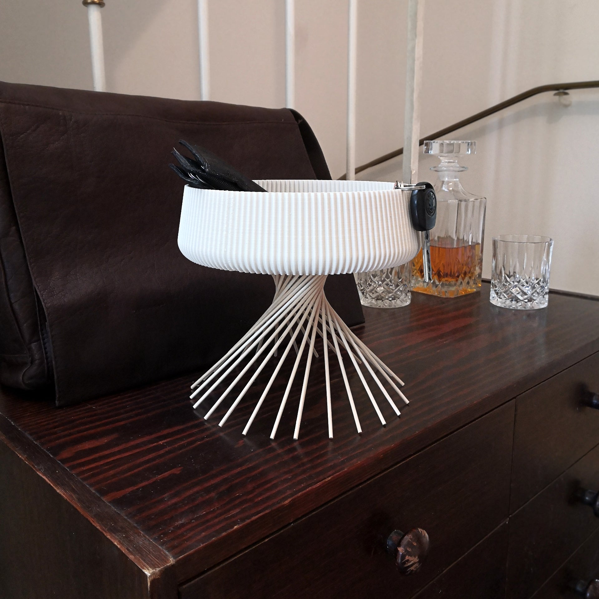 a wooden dresser topped with glasses and a whisk