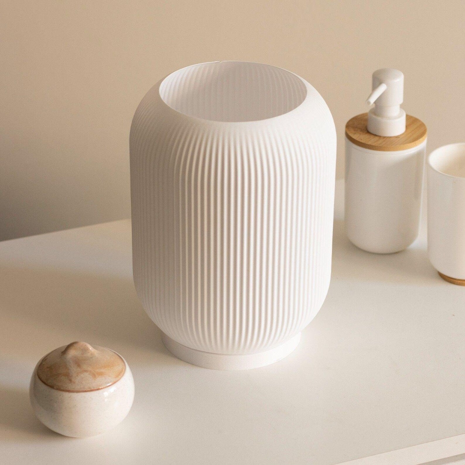 a white vase sitting on top of a white table