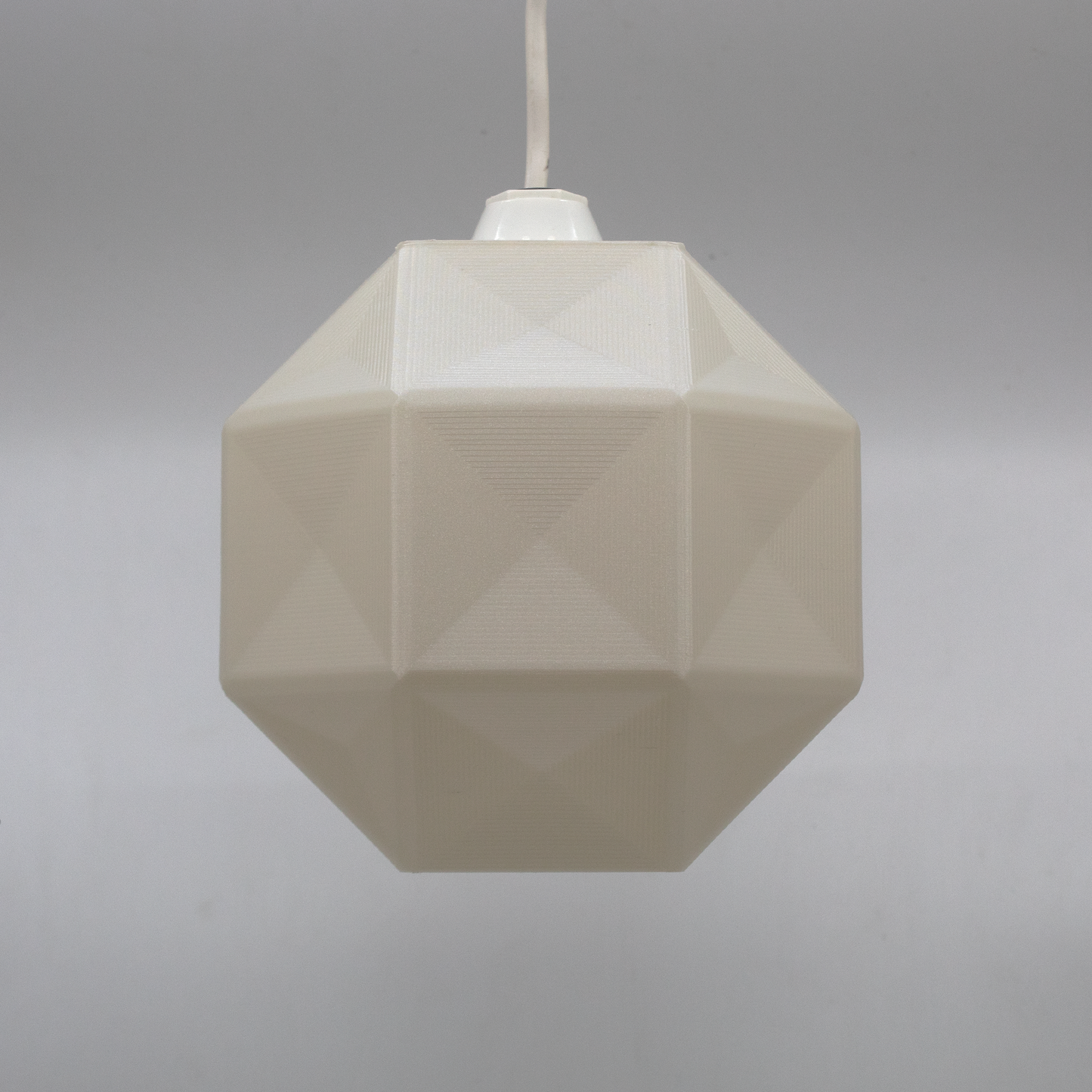 a white light hanging from a white ceiling