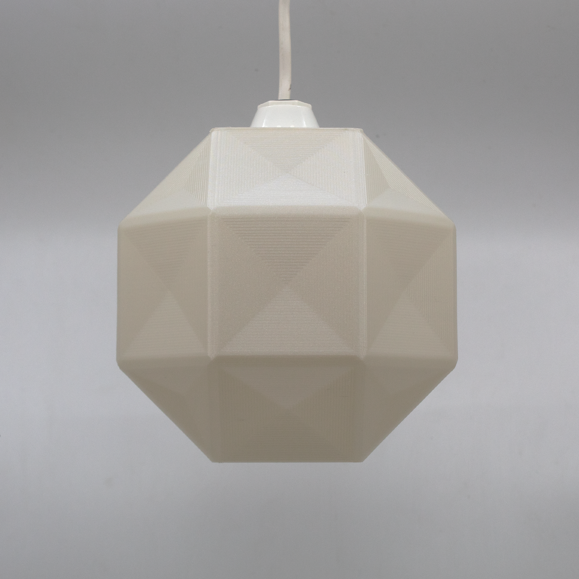 a white light hanging from a white ceiling