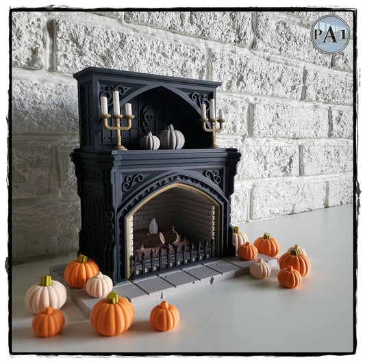 a miniature fireplace with a black exterior and gold accents, surrounded by a collection of small orange pumpkins.
