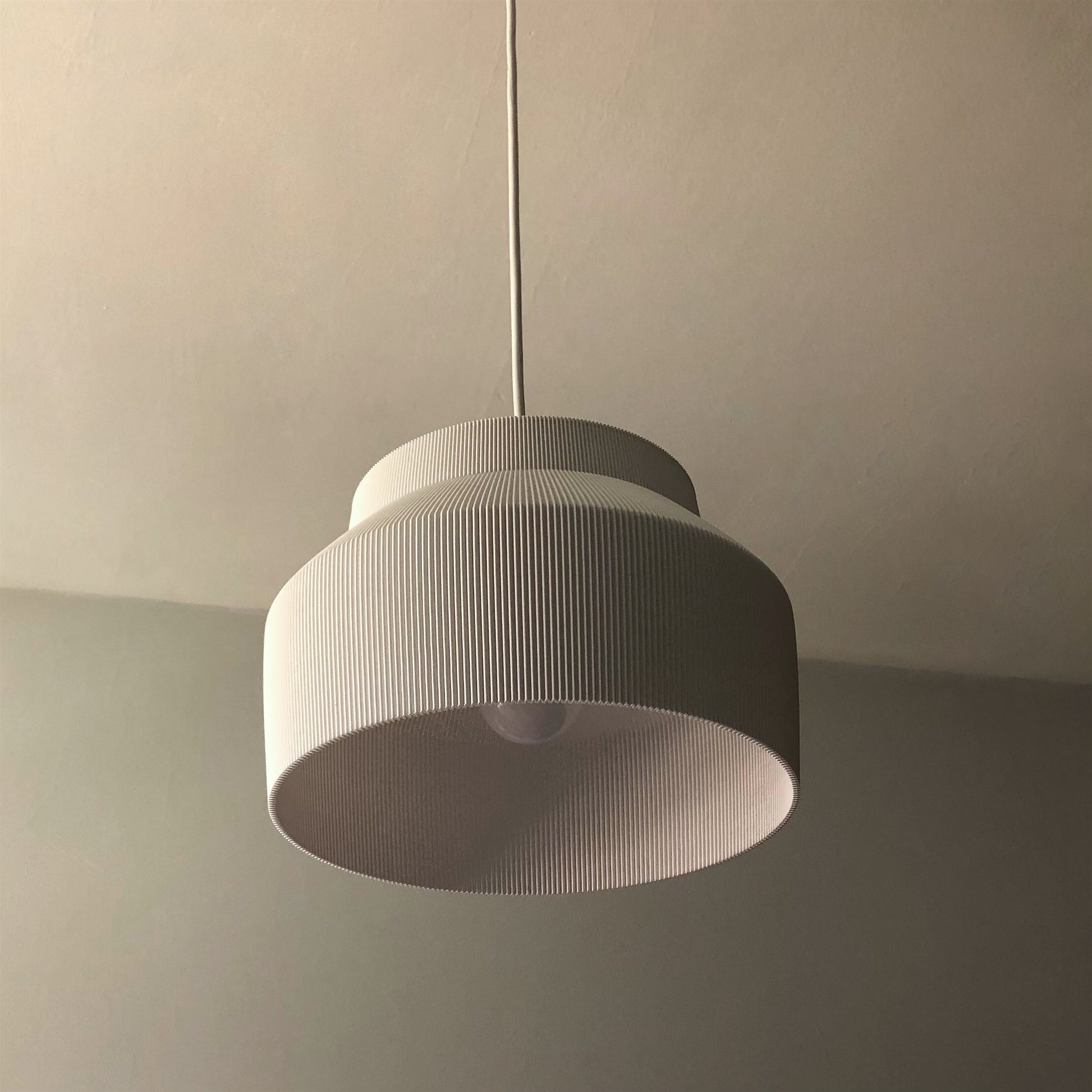 a white light hanging from a ceiling in a room