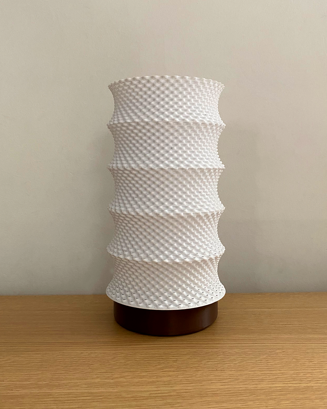 a white vase sitting on top of a wooden table