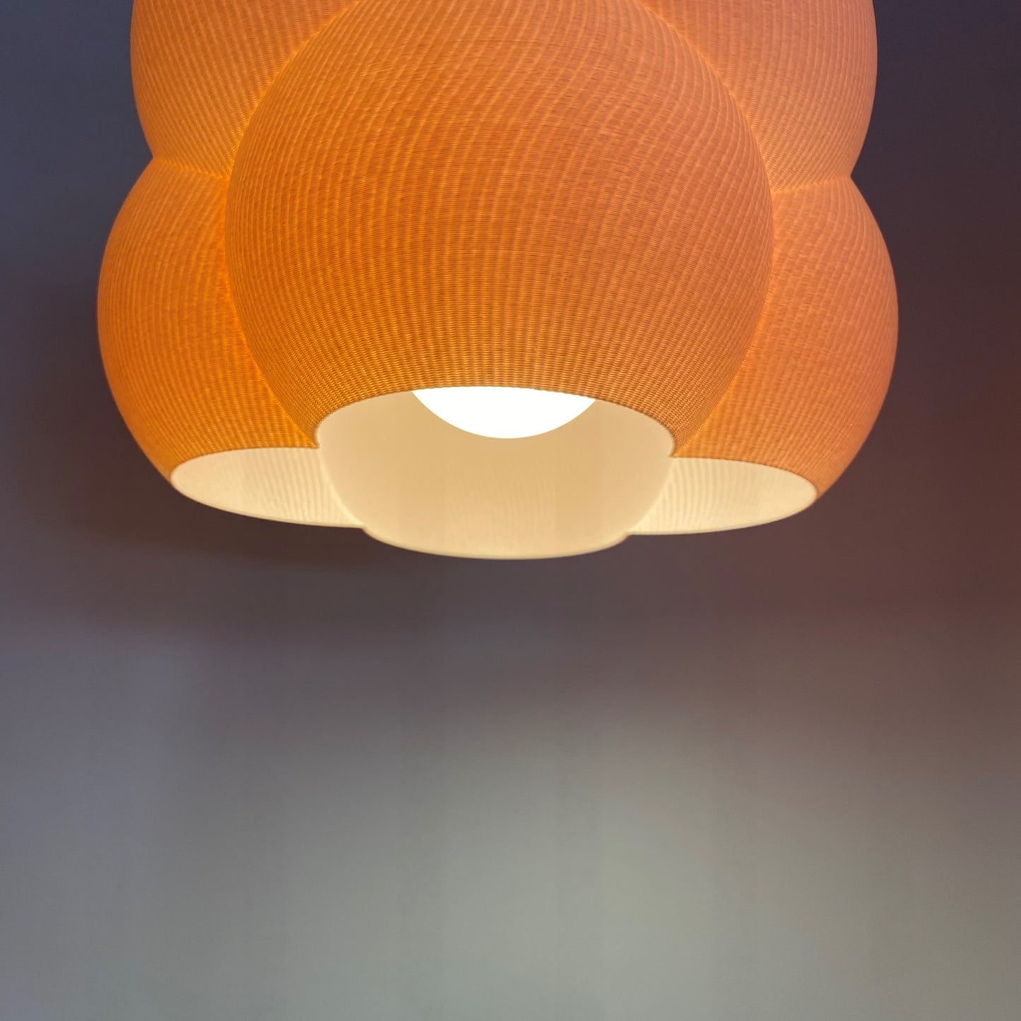 an orange lamp hanging from a ceiling in a room