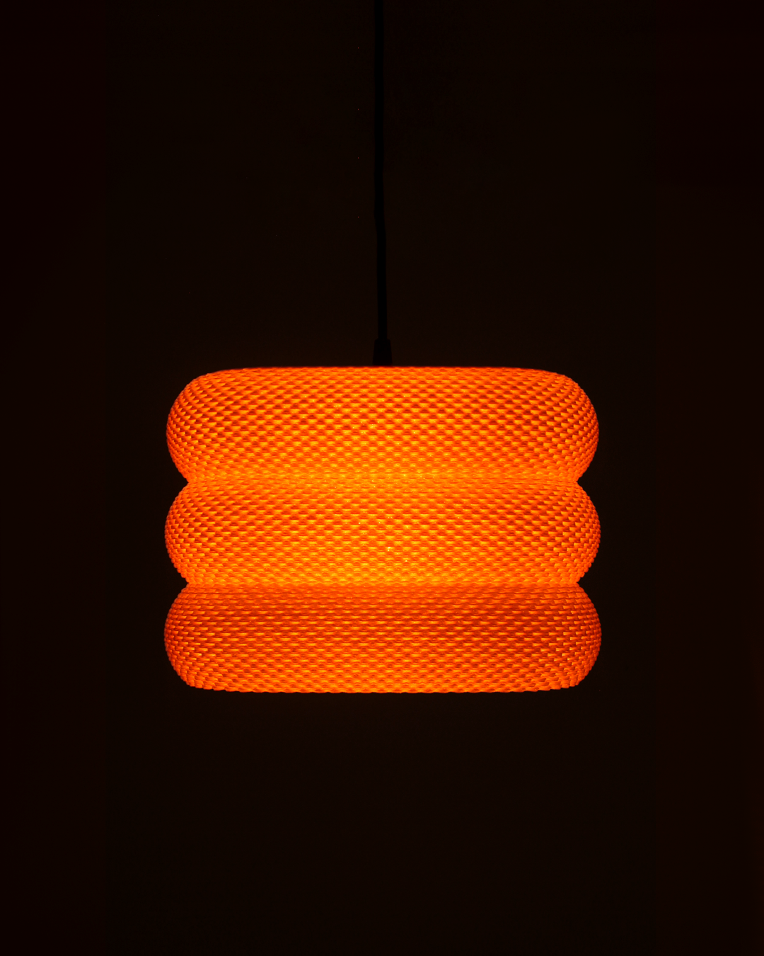 an orange light hanging from a ceiling in a dark room