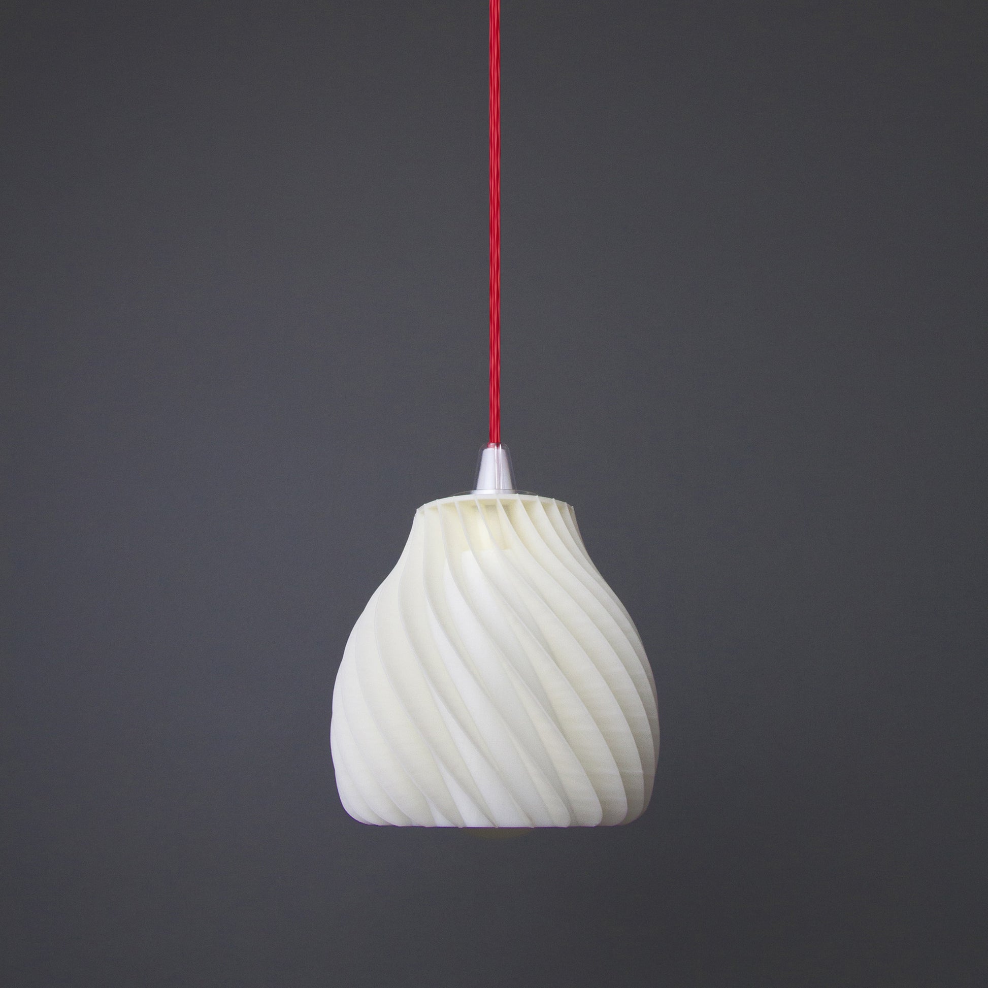 a white light bulb hanging from a red cord