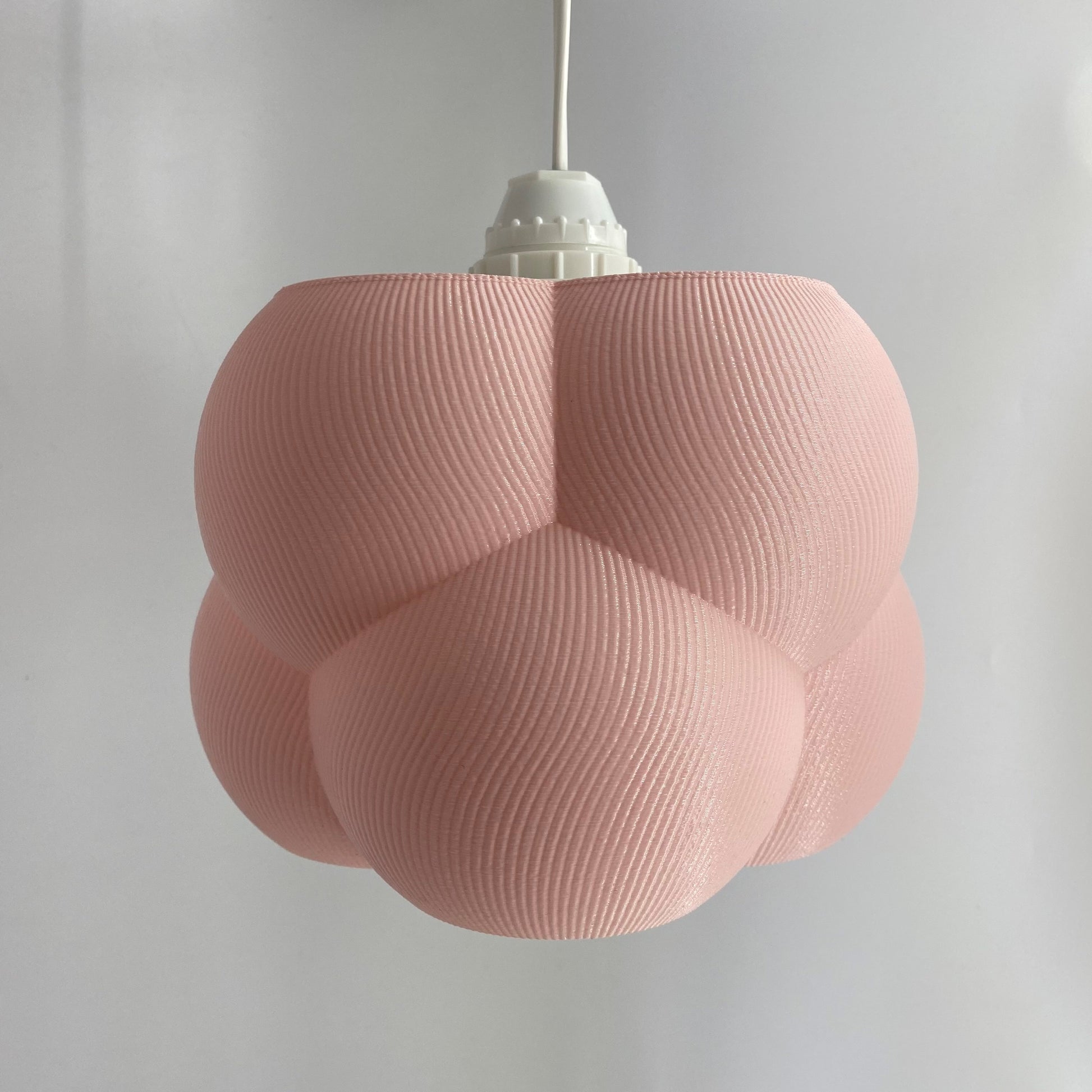 a pink light fixture hanging from a ceiling