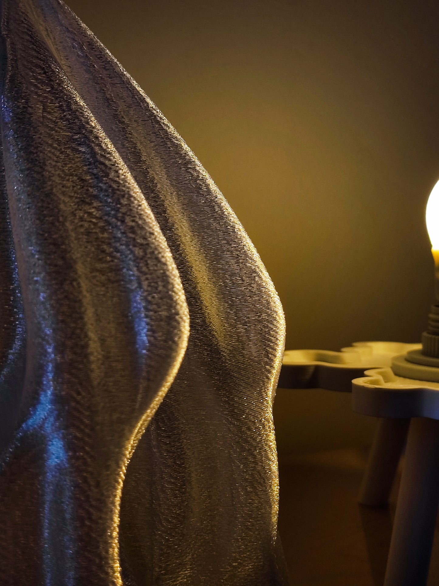 a towel draped over a table with a lit candle