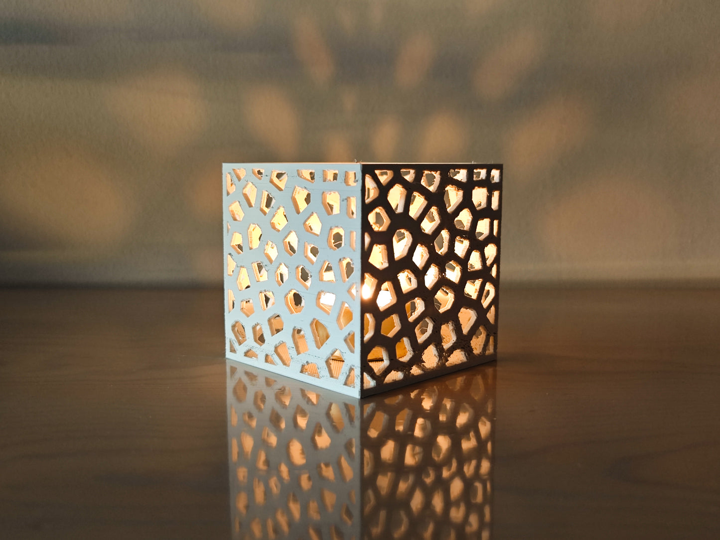 a lit candle holder sitting on top of a table