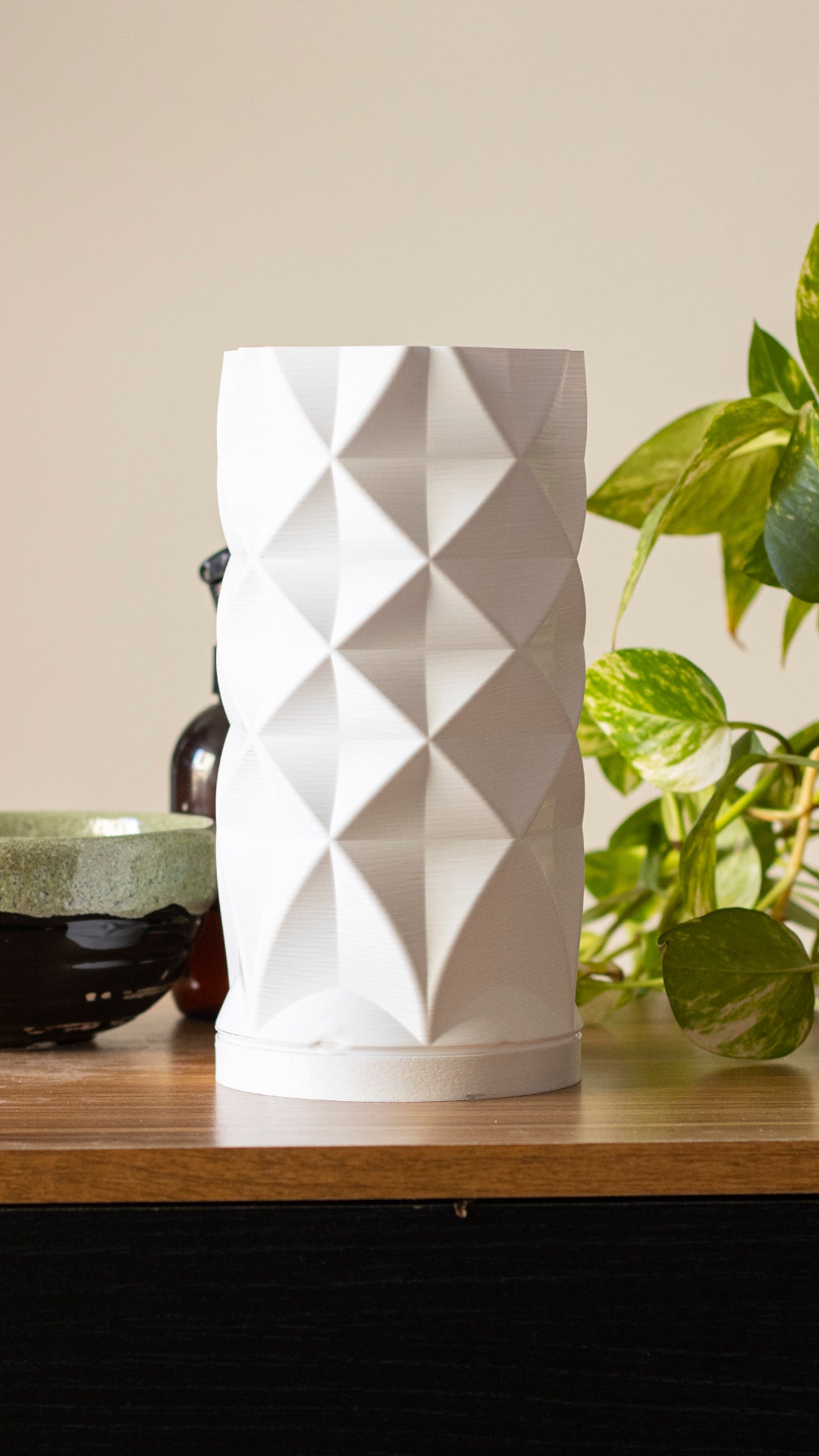 a white vase sitting on top of a wooden table
