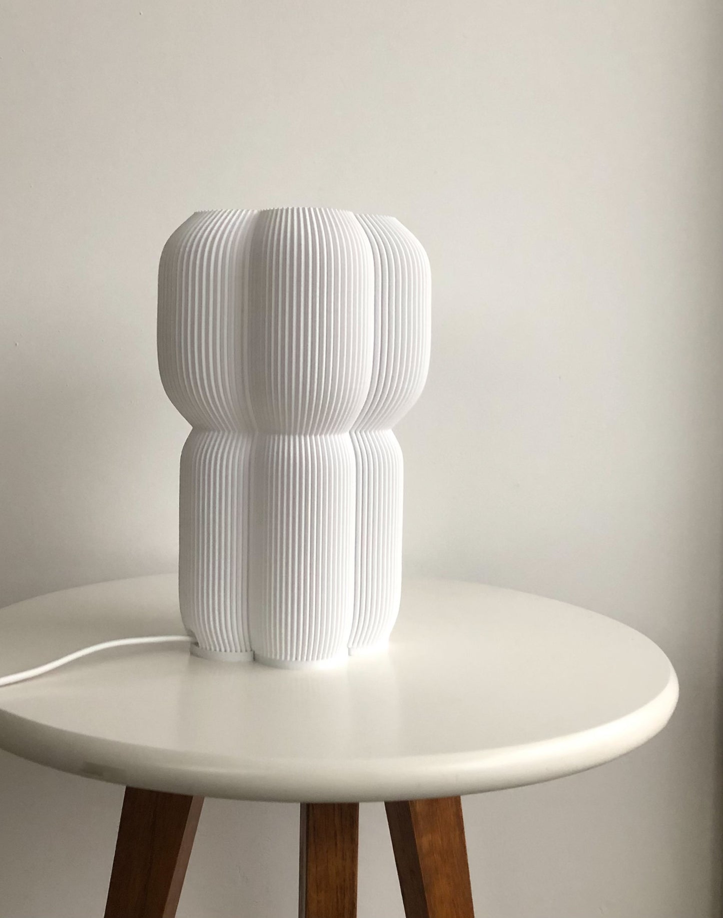 a white lamp sitting on top of a white table