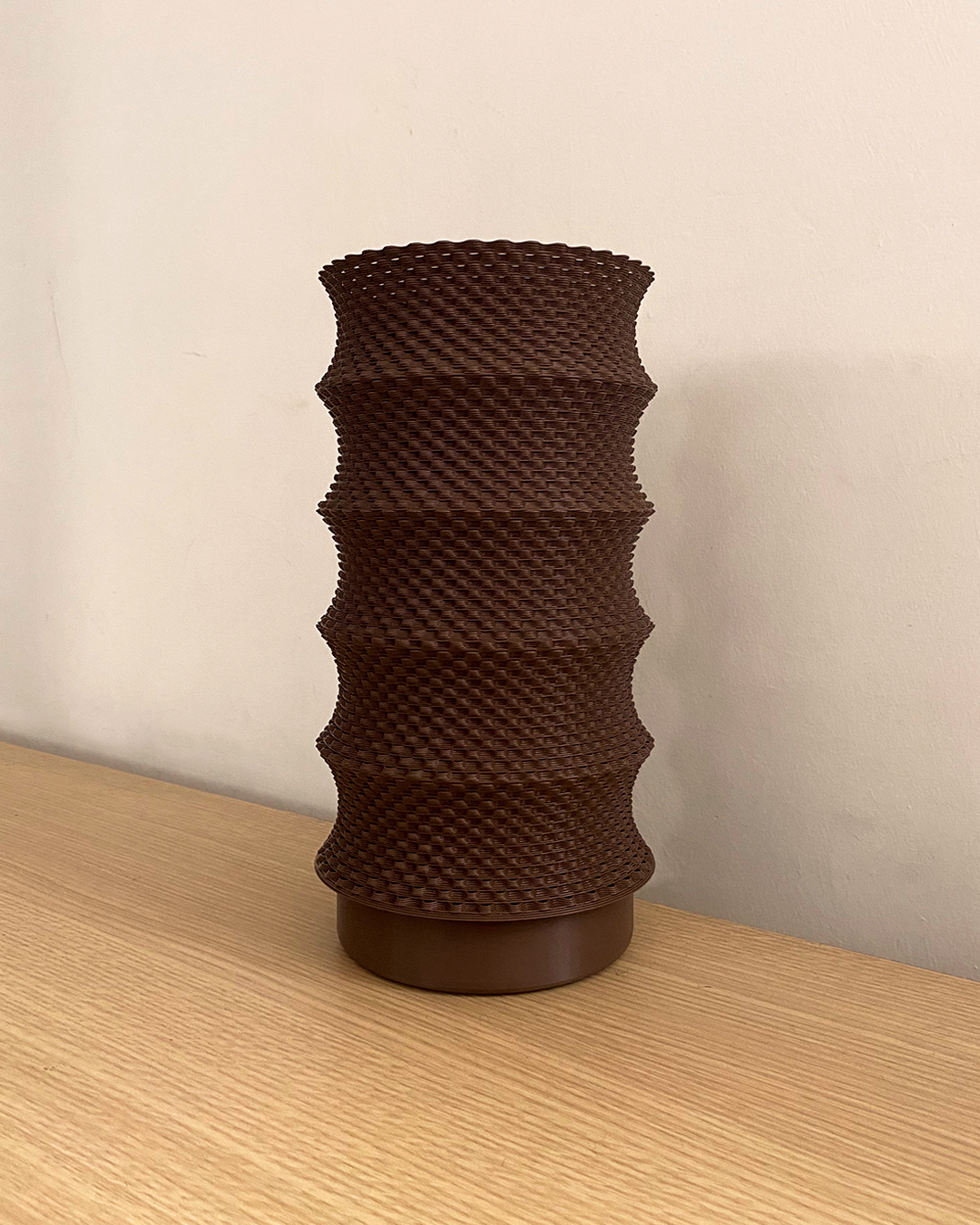 a brown vase sitting on top of a wooden table