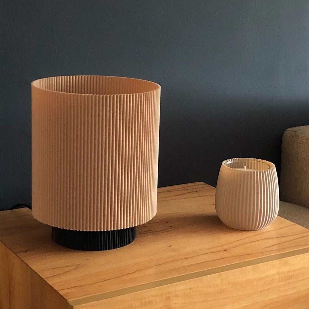 a wooden table topped with a vase and a cup