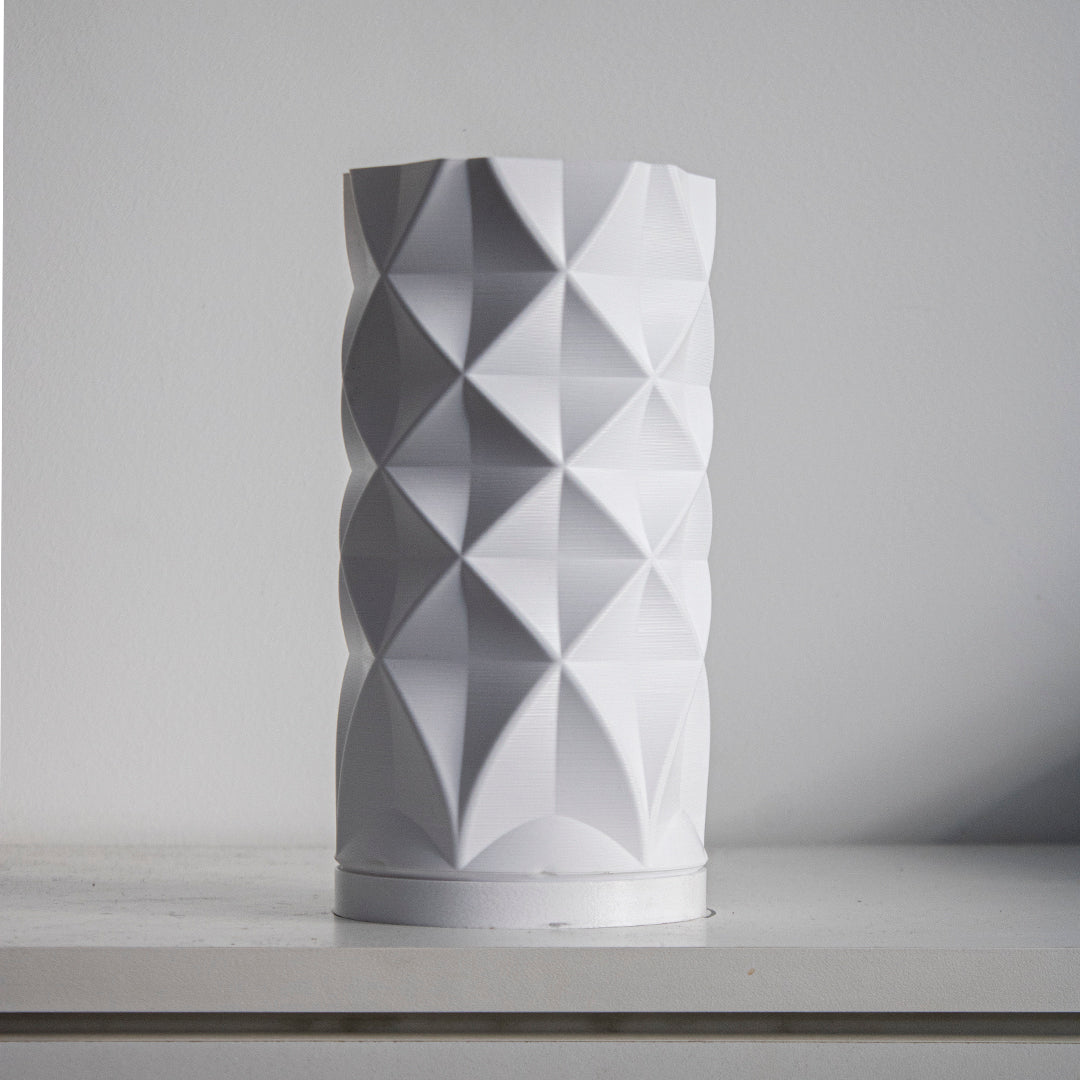 a white vase sitting on top of a shelf