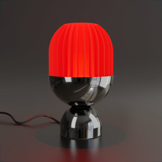 a red and black lamp on a black surface