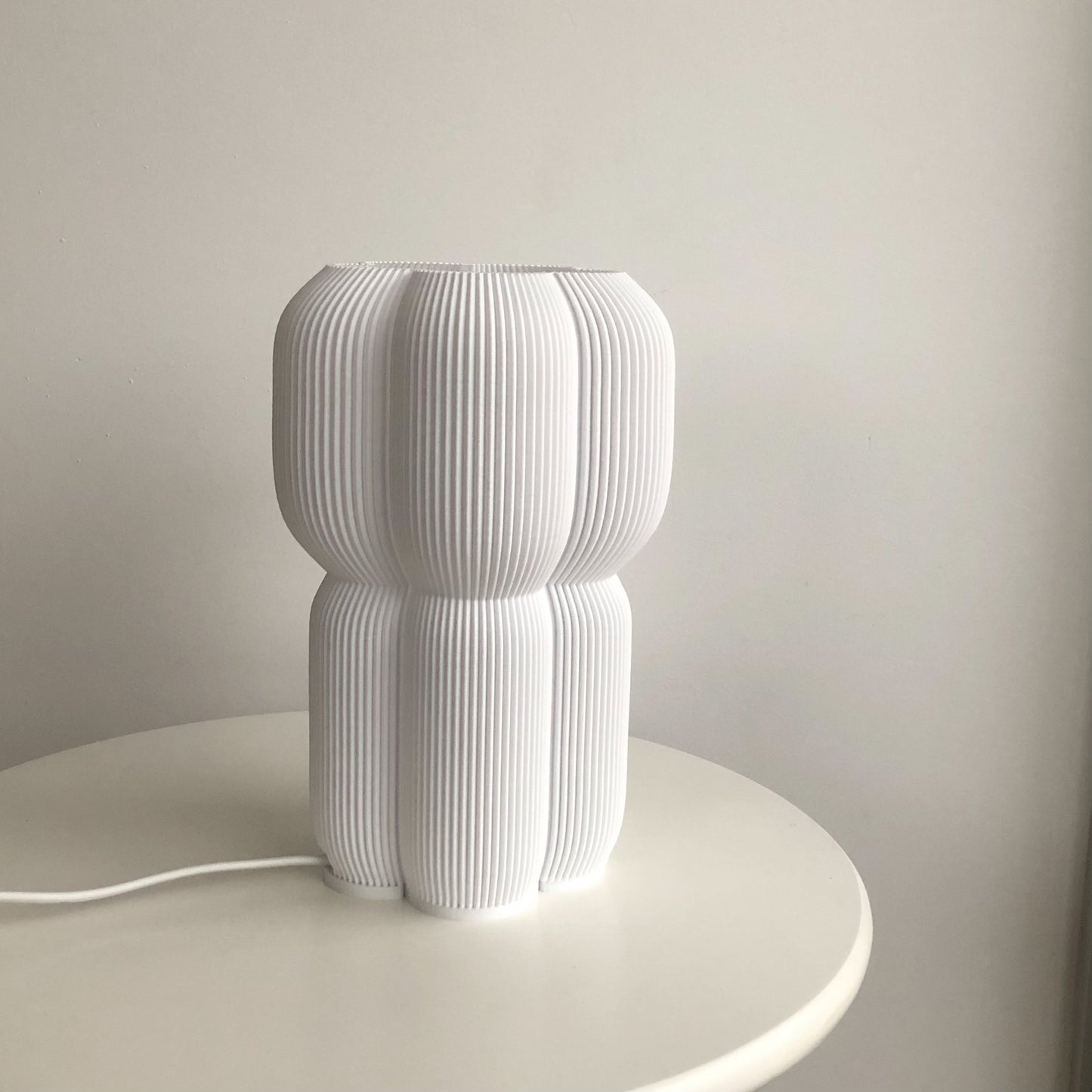 a white lamp sitting on top of a white table