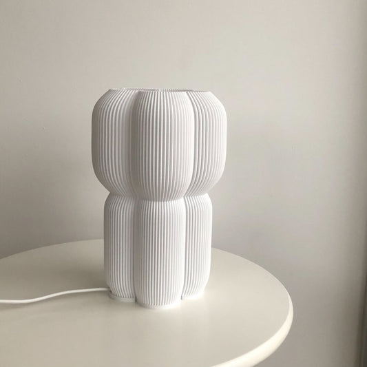 a white lamp sitting on top of a white table