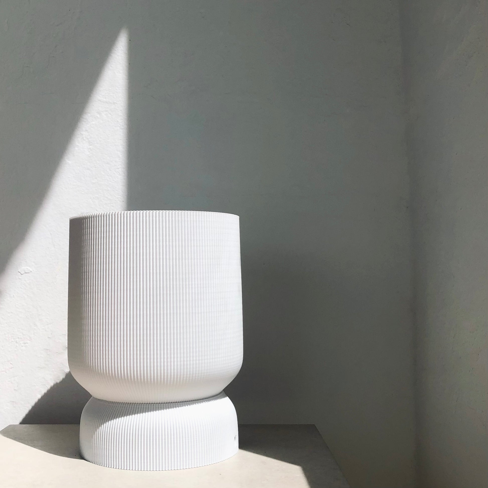 a white vase sitting on top of a table