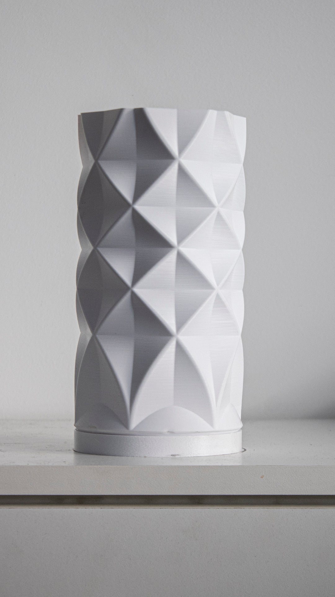 a white vase sitting on top of a counter