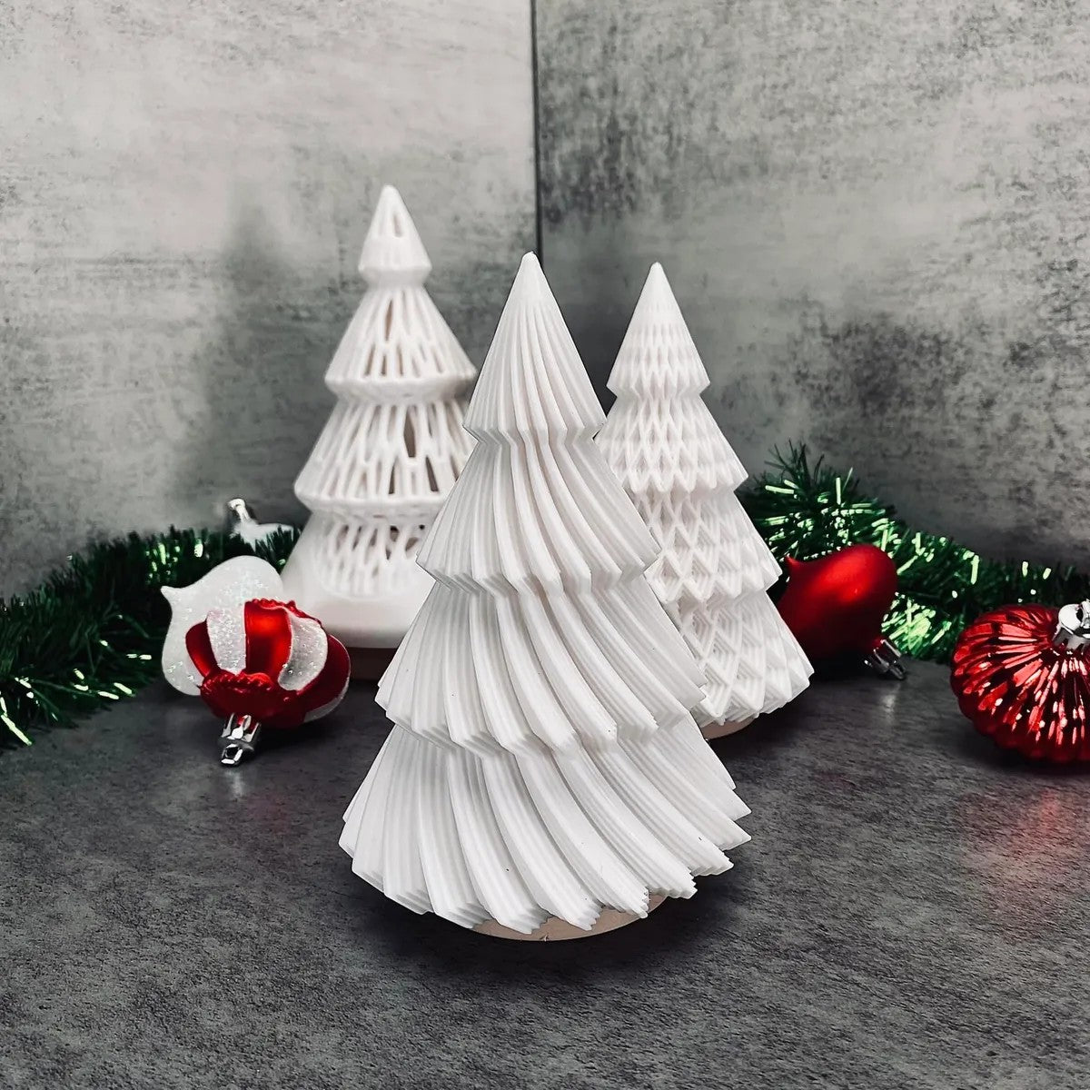 a group of white christmas trees sitting on top of a table