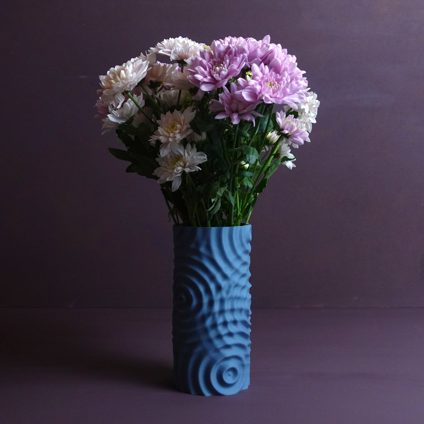 a blue vase filled with purple and white flowers